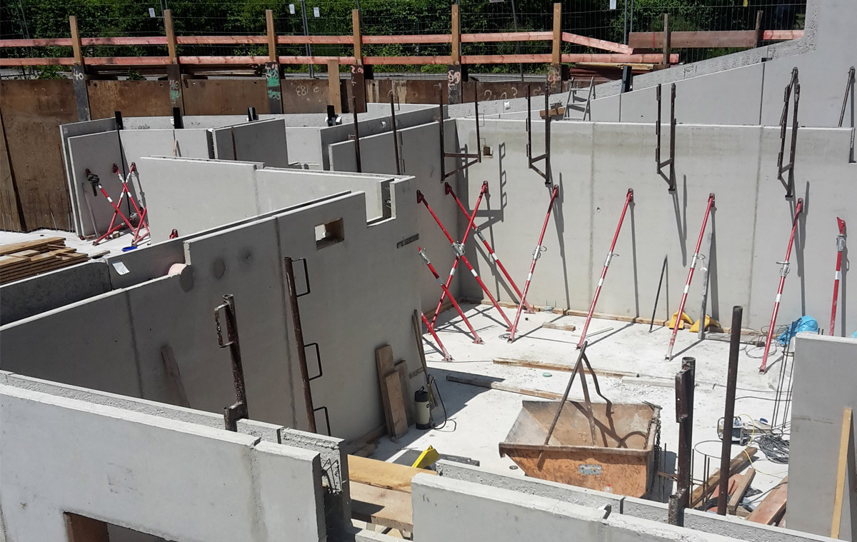 Baustelle des Neubaus eines Mehrfamilienhauses mit Tiefgarage in Unterhaching (2018), Blick auf die gestellten Betonfertigteile im Rohbau. Baustelle des Neubaus eines Mehrfamilienhauses mit Tiefgarage in Unterhaching (2018), Blick auf die gestellten Betonfertigteile im Rohbau.